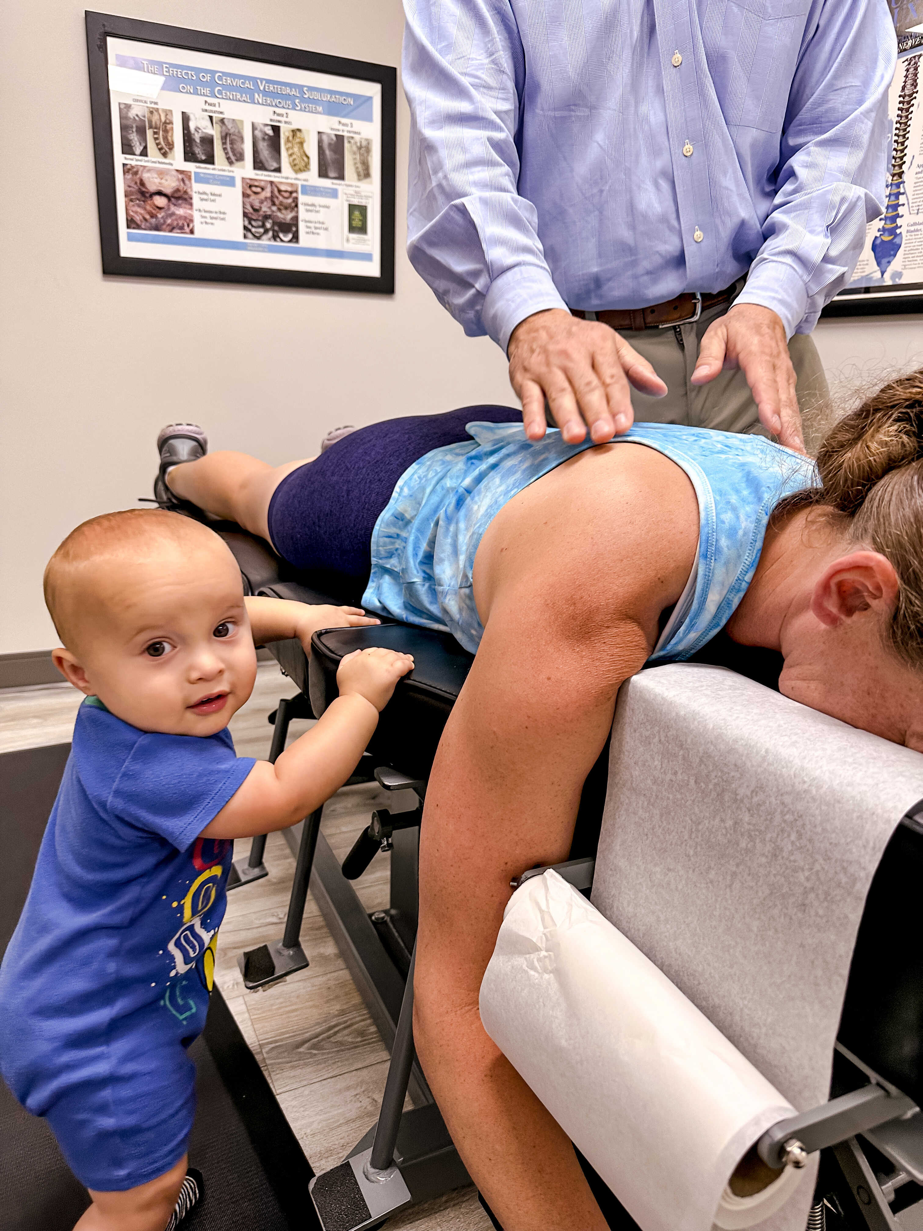 Dr. Dan Durrieu adjusting a patient while her baby watches at Family Health Chiropractic, Tampa